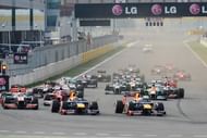 Sebastian Vettel of Germany (R) leads the pack at the start